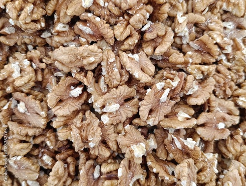 Market stall display with assorted bulk nuts for sale by weight, including walnuts, cashews, almonds, and mixed nuts.