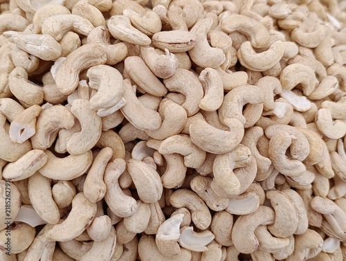 Market stall display with assorted bulk nuts for sale by weight, including walnuts, cashews, almonds, and mixed nuts.