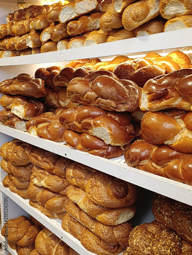 Market stall display with traditional challah bread, braided Shabbat loaves, and Jewish egg bread for sale.
