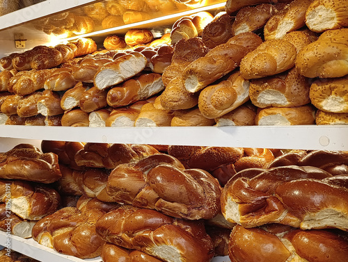 Market stall display with traditional challah bread, braided Shabbat loaves, and Jewish egg bread for sale.