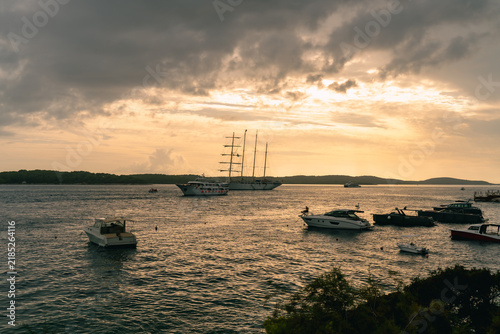 Fotografie Sailing ship and boats at sunset near Hvar island Croatia