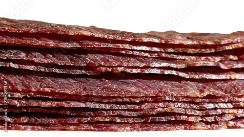 Картината върху платно Isolated Stack of delicious and thin red beef jerky slices, traditional savory snack food