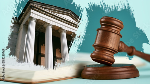 Wooden judge gavel beside an open law book and classical courthouse, illustrating law, justice, legal education, court proceedings and the judicial system.