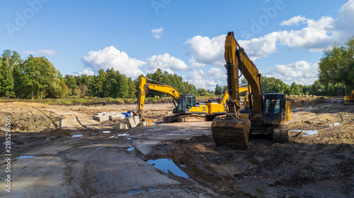Foto Crawler excavators level the ground at a construction site for a building under construction