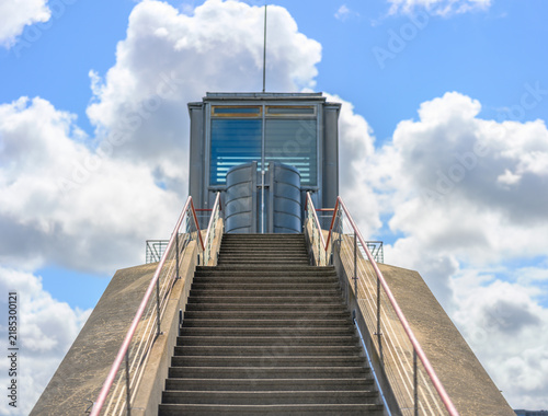Canvas Print Symmetrical concrete staircase rising toward modern waterfront structure