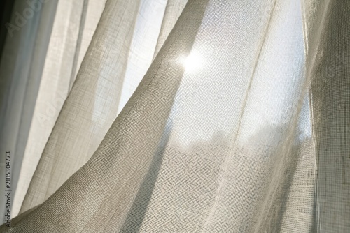 Sunlight through sheer curtains illuminating a room during the afternoon