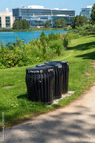 Фотография Vertical photo of recycling and waste bins in a public park, showing separate co