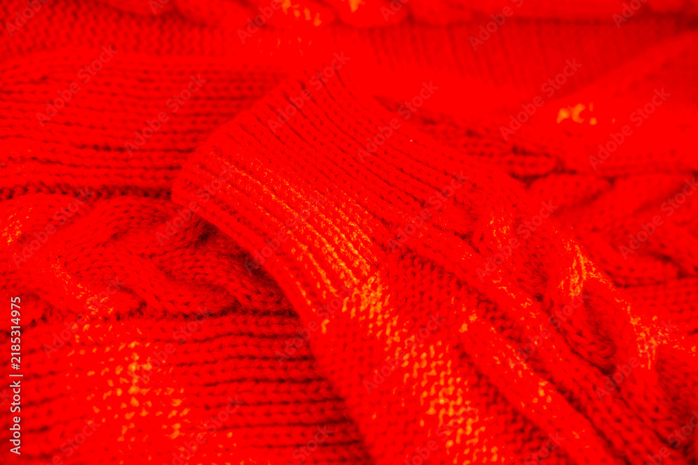 Fototapeta premium red knitted sweater texture with soft wool threads and cozy stitches, warm winter clothing background, handmade feel, detailed fabric pattern, comfortable seasonal apparel