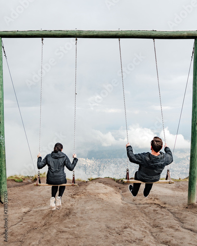 Obraz na plátně Couple swinging on the top of mountain above Quito Ecuador