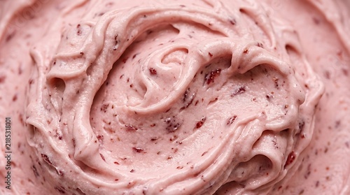 Close-up of creamy pink strawberry ice cream swirled with visible fruit pieces dessert sweet