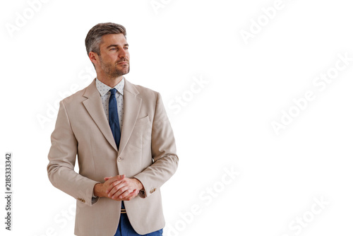 Confident business man in formal wear standing and looking away  hands clasped  portraying leadership and success