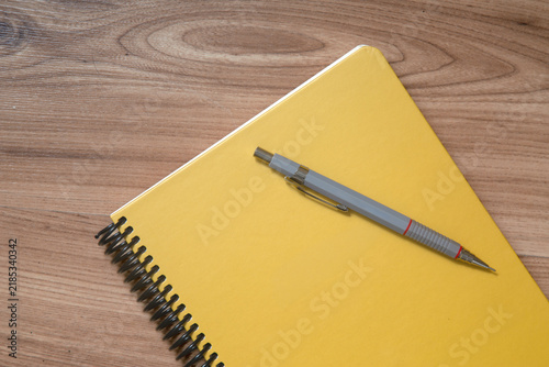 Top view of kraft paper notebook, page, pencil