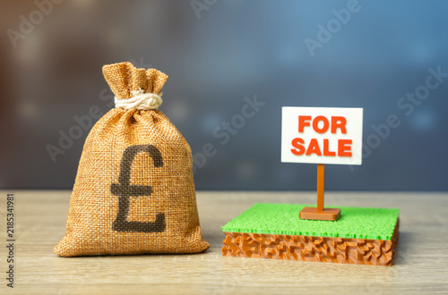 Bild auf Leinwand An British pounds money bag and a plot of land for sale