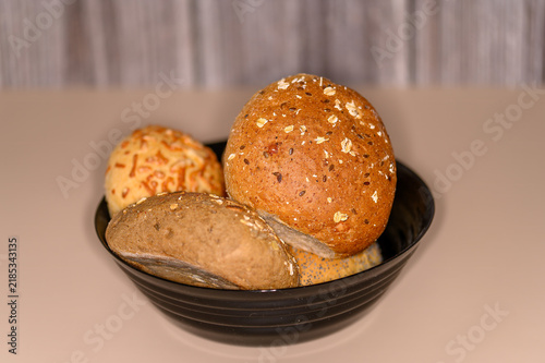 Fotografie A bowl holds several types of bread rolls