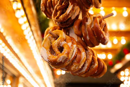 Bretzels salés suspendus à un stand de marché de Noël, ambiance chaleureuse