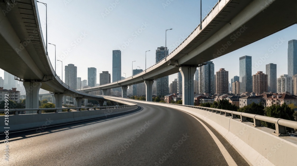 Obraz premium Empty elevated highway curves toward modern city skyline. Concrete overpasses span across urban landscape with tall skyscrapers and buildings under clear sky.