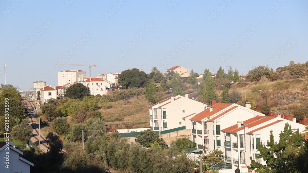 Fototapeta premium CASTELO BRANCO, PORTUGAL - AUGUST 22, 2026: General view of Castelo Branco city in the Beira Baixa region of central Portugal Residential buildings and railway tracks in a suburban landscape