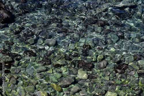 Bild auf Leinwand Crystal clear shallow water over stony seabed with natural sunlight for use as b