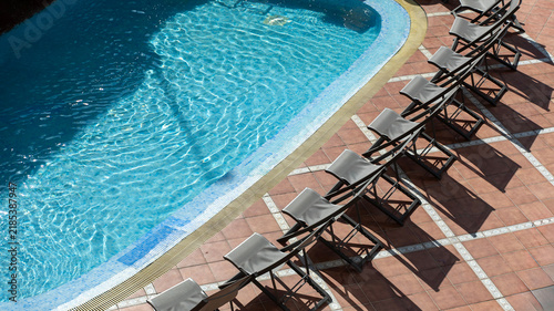 Cuadro en lienzo Swimming Pool with Row of Sun Loungers on a Sunny Resort Terrace