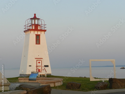 Historic Red and White Canadian Wooden Lighthouse on Coast at Dusk