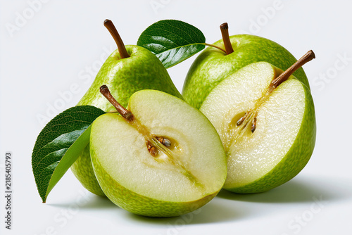 Green pears cut in half with leaves on a light background