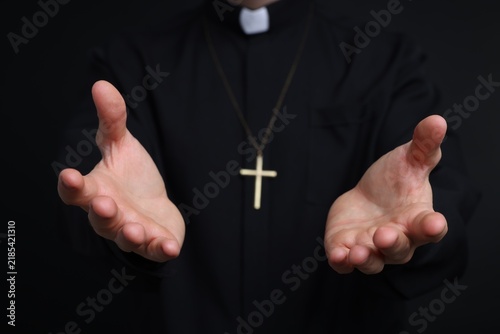 фотографія Priest in cassock on black background, closeup