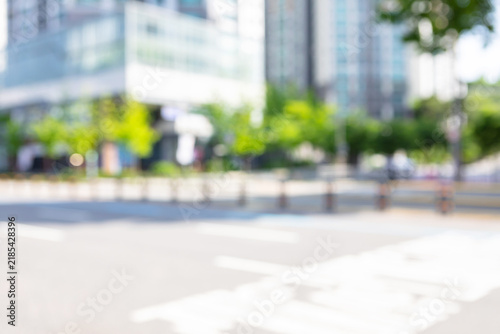 Abstract blurred modern downtown public avenue background with crosswalk markings and high-rise office buildings 