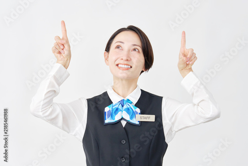 上を指差す女性スタッフ　受付嬢・銀行員　白背景