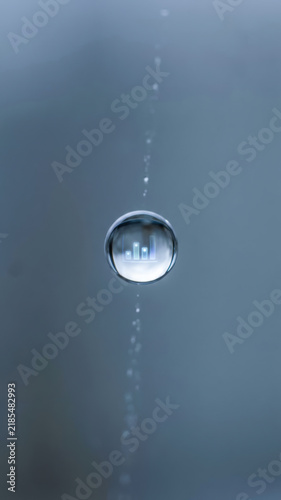 Water droplet reflection blue data driven decision making concept with suspended bubble and rising air trail in clear liquid