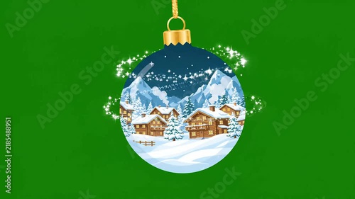 Magical Christmas bauble hanging on green background showcasing a snowy alpine village with mountains. Perfect for holiday greeting video projects.