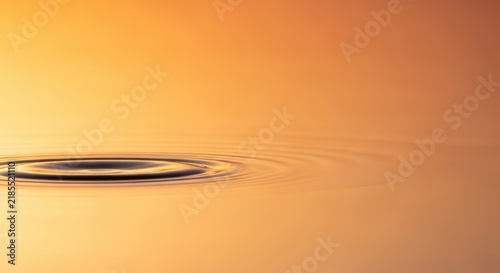 Ripples on a golden surface, abstract background with copy space.