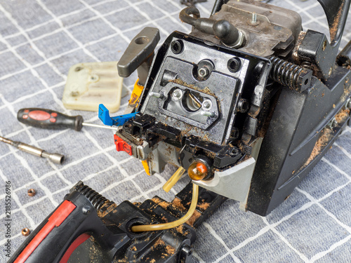 Bild auf Leinwand Disassembled gasoline chainsaw engine undergoing repair and maintenance, with ex