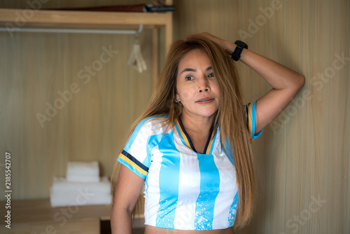 A woman is wearing a blue and white football team jersey, only the upper half of her body is visible.