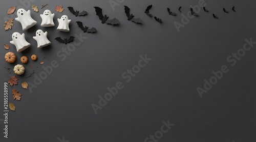Top view of halloween decorations featuring small ghost figures and black bats arranged on a dark background
