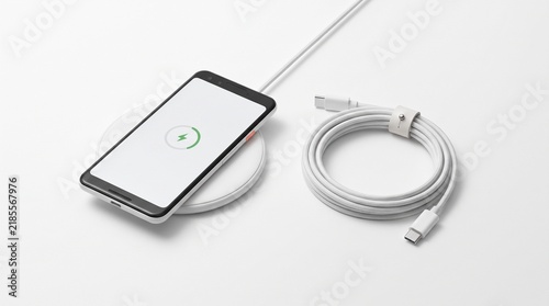 Smartphone charging on a round wireless charging pad with white cable