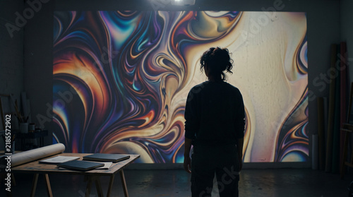 Digital Artist Viewing Abstract Generative Artwork in Studio