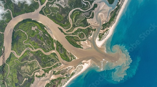 Cuadro en lienzo Aerial view of a winding river delta meeting the ocean with swirling sediment an
