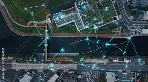 Obraz w ramie Aerial view of smart city network with glowing blue connection lines linking buildings and roads, futuristic internet of things infrastructure and wireless communication system