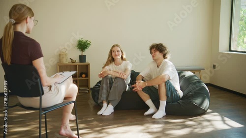 Couple engages in a psychology session with therapist in a bright indoor space designed for comfort and openness