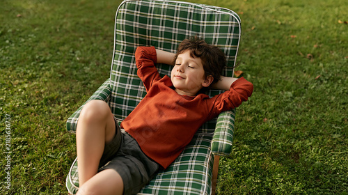Relaxed Child Resting on Outdoor Lounge Chair Enjoying a Peaceful Summer Afternoon in the Garden