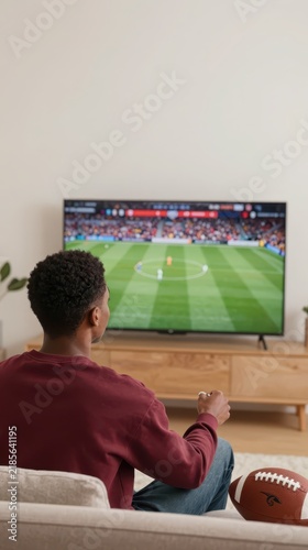 Person watching a football game on television at home