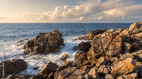 Rugged Rocky Coastline with Waves Crashing Against Weathered Rocks at Sunset
