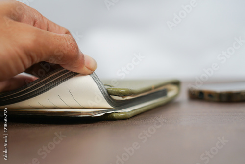 Fotografie Hand Opening a Worn Wallet With Cash