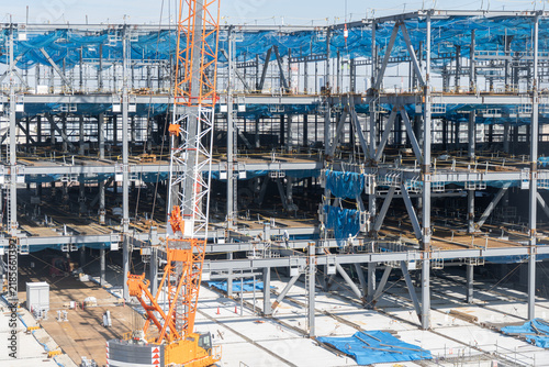 Obraz na płótnie クレーンで鉄骨を吊り上げ作業員が誘導する鉄骨建方工事