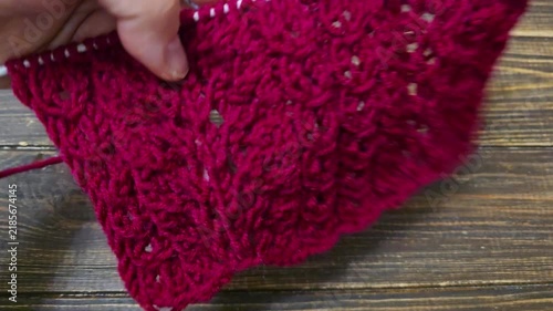 Multicolored hand-knitted fabric. Knitting and crochet lessons. Fashion and education. Training for artificial intelligence. Hands in the frame.