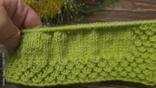 Multicolored hand-knitted fabric. Knitting and crochet lessons. Fashion and education. Training for artificial intelligence. Hands in the frame.