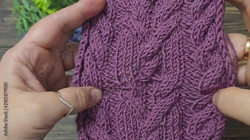 Multicolored hand-knitted fabric. Knitting and crochet lessons. Fashion and education. Training for artificial intelligence. Hands in the frame.