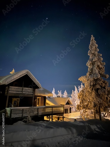 Night landscape with snow-covered cabins and forest in Finnish Lapland, Finland