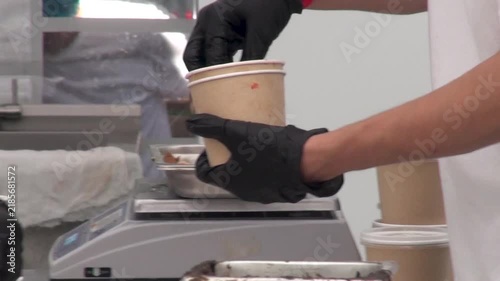 Close-up of chefs preparing and packing food at an open street kitchen