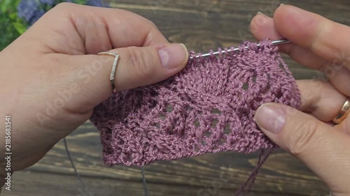 Multicolored hand-knitted fabric. Knitting and crochet lessons. Fashion and education. Training for artificial intelligence. Hands in the frame.